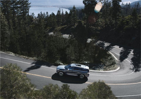 A 2023 Lincoln Aviator® SUV is being driven on a winding mountain road | Kirk Brothers Lincoln of Vicksburg in Vicksburg MS