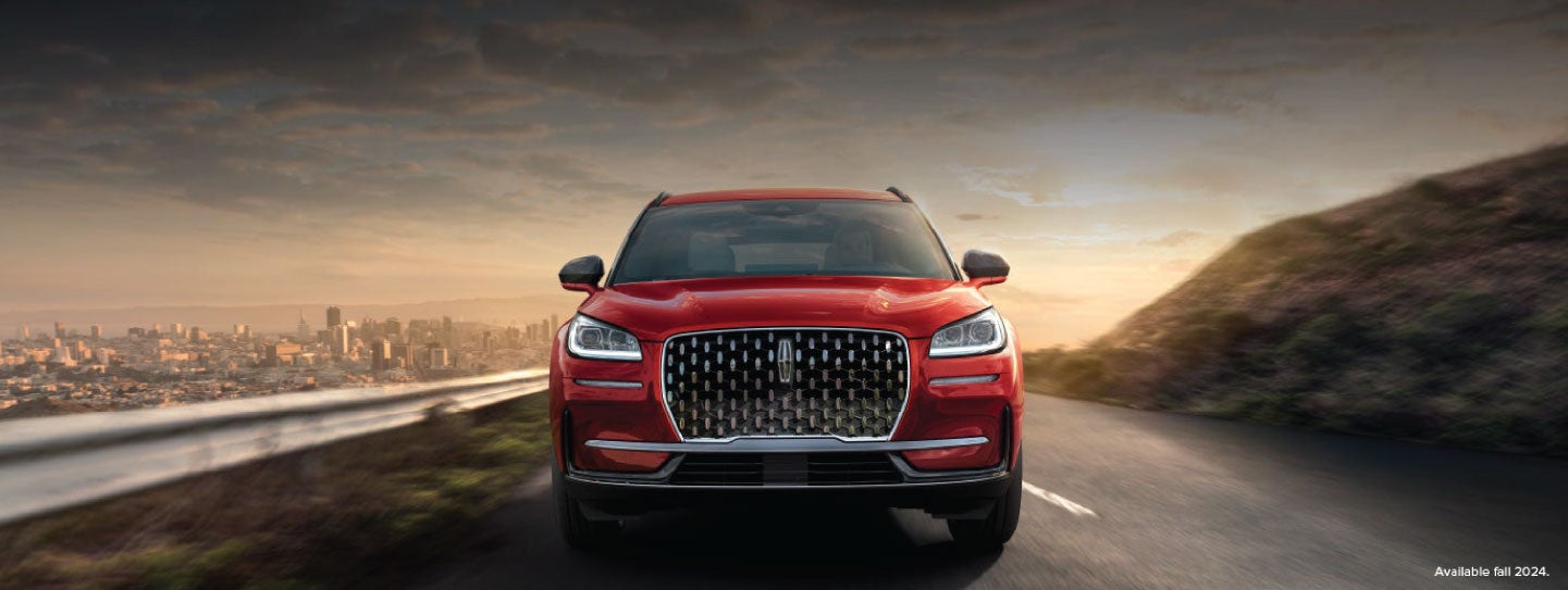 A 2025 red Lincoln Corsair® SUV is being driven down a road at sunset. | Kirk Brothers Lincoln of Vicksburg in Vicksburg MS