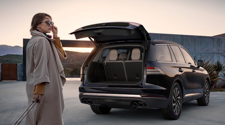 A woman approaches a 2026 Lincoln Aviator® SUV with its rear liftgate open. | Kirk Brothers Lincoln of Vicksburg in Vicksburg MS